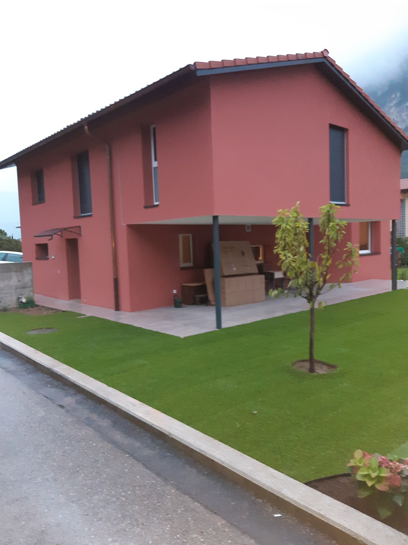 Abitazione con facciata rossa e giardino