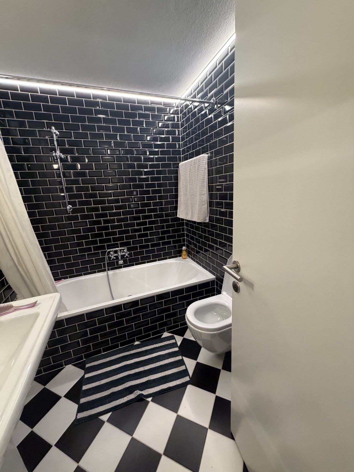 Bagno con vasca e rivestimenti scuri